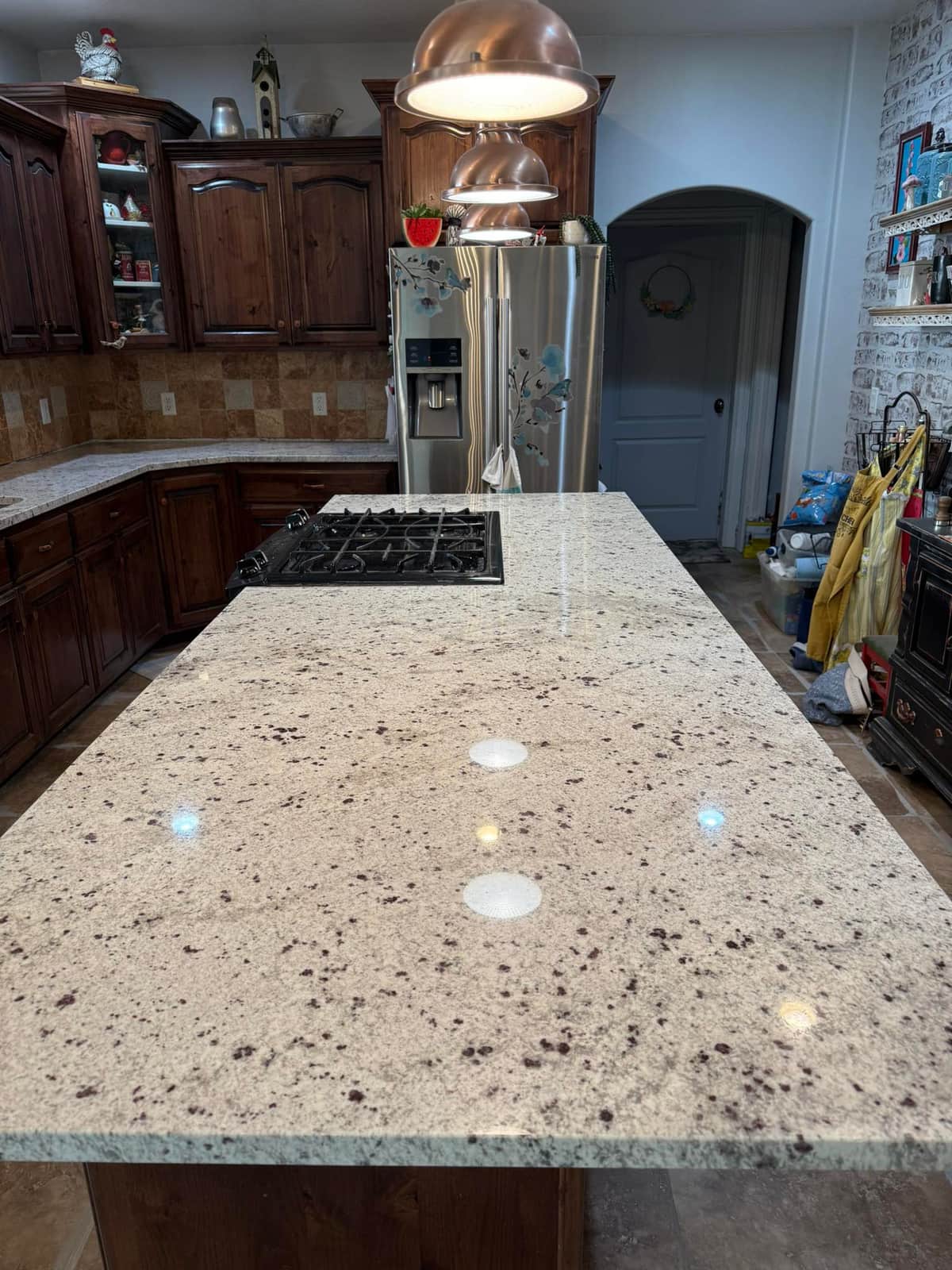 Rustic kitchen with granite island and copper pendant
