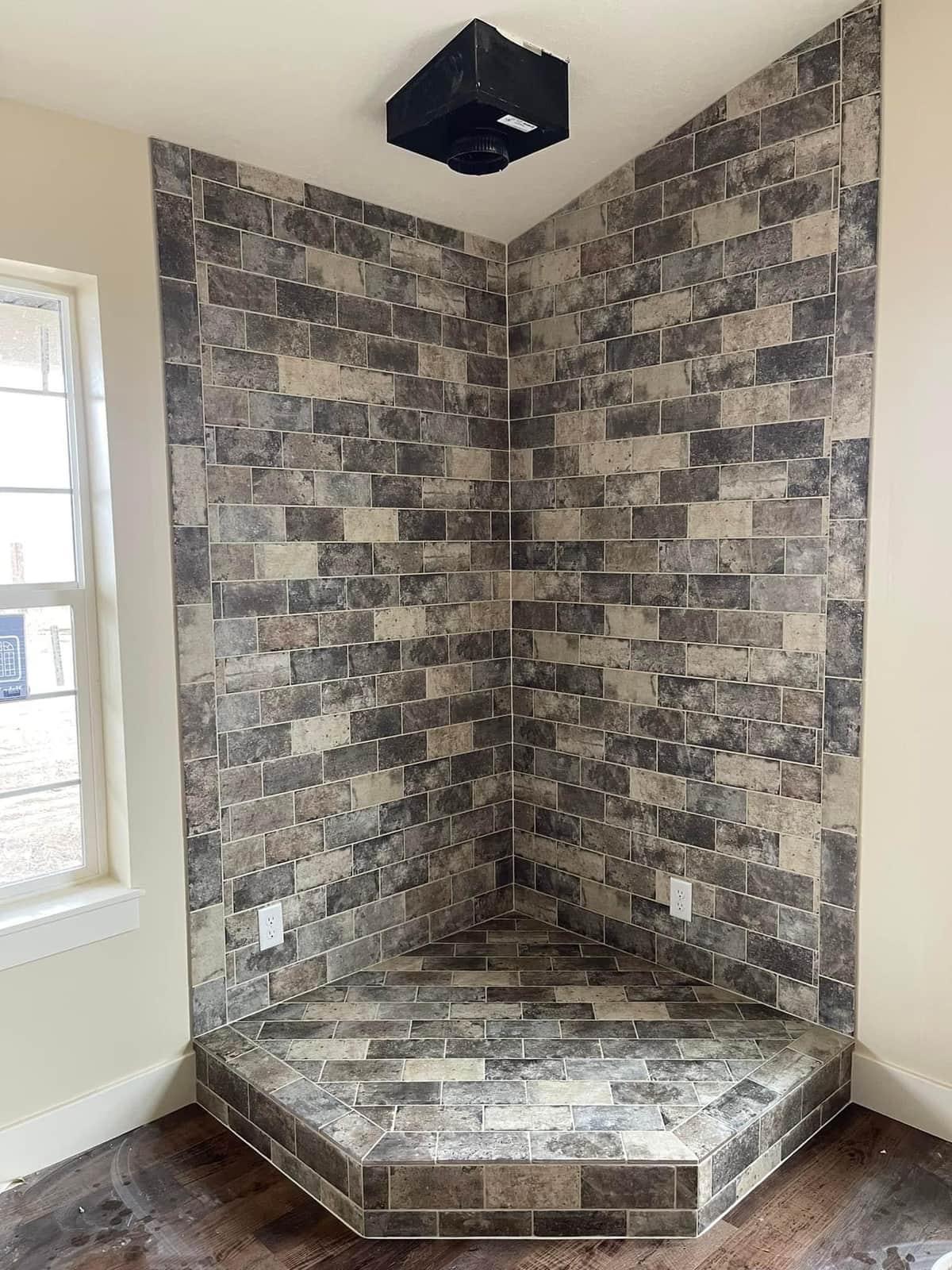 Rustic stacked-stone corner shower bench