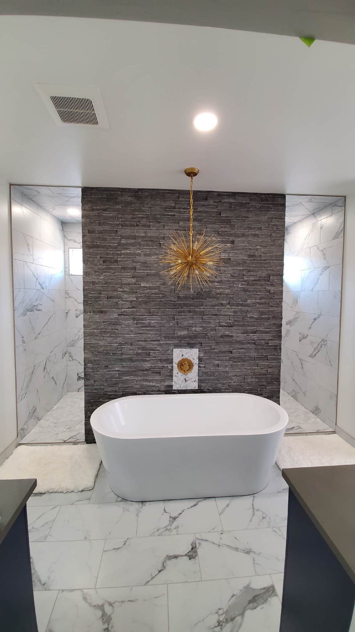 Freestanding tub with a marble feature wall