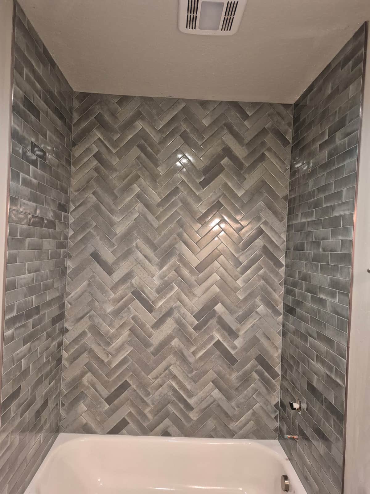 Gray herringbone tile tub surround